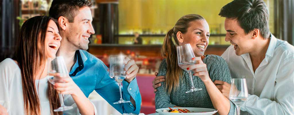 Twee jonge stellen lunchen in een restaurant